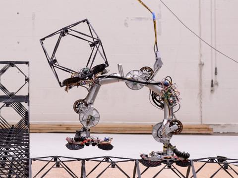 The SOLL E robot is shown taking a step across the lattice structure
