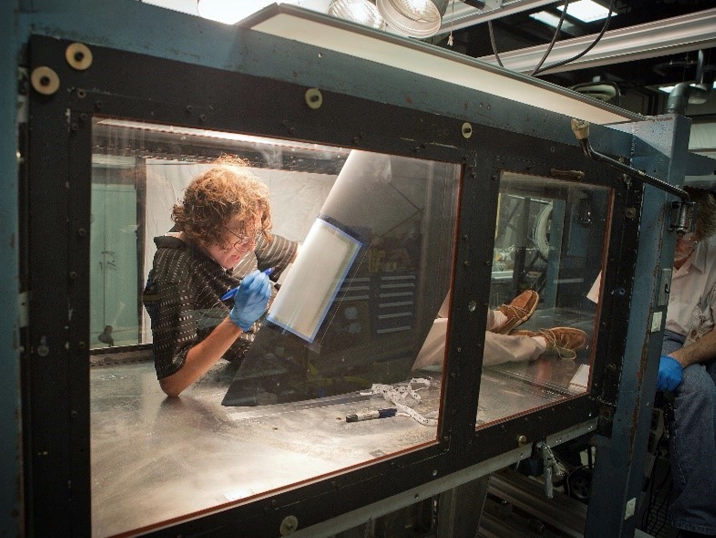 NASA researcher preps model wing for a blast from the "bug gun."