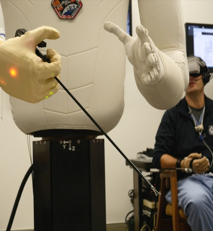 R2 holding a surgical tool during a teleoperated medical procedure test session with the Methodist Hospital surgeons and NASA engineers.